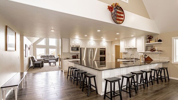 A spacious kitchen with a large island, bar stools, and modern appliances.