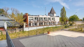 Een gebouw in moderne bouwstijl, met een opvallende toren en een balkon.