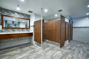 A modern bathroom with a large mirror, wooden vanity, and a tiled floor. - Spectacular garden views. A short walk to the beach, restaurants, and shops! (Oceanside)