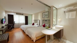 A hotel room with two beds, a desk, a chair, a TV, a bathroom with a sink and a mirror, and a shower. - Fu Yi Fashion Hotel (Chongqing)