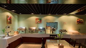 A restaurant with a long counter, multiple buffet stations, and a ceiling with a grid pattern. - Fu Yi Fashion Hotel (Chongqing)
