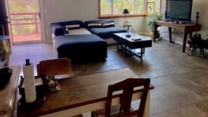 A living room with a sofa, a coffee table, a TV, and a dining area with a table and chairs. - Main house in the heart of Sedona (Sedona)
