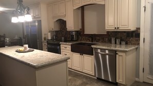 A kitchen with white cabinets, a stainless steel dishwasher, and granite countertops. - Main house in the heart of Sedona (Sedona)