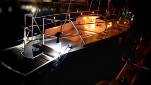 Un modellino di barca con cabina, ponte e ringhiera.