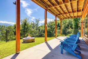 Un espace extérieur abrité, doté d’un foyer, de sièges et offrant une vue sur une montagne.