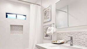 A modern bathroom with a white sink, vanity, and toilet. There is a shower curtain, a window, and a mirror above the sink. - Top-Rated 2BR Home · 5 Miles to Disneyland (Fullerton)