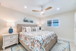 A bedroom with a bed, nightstands, a ceiling fan, and a window. - OCEAN'S REACH 1B4, 1-Bedroom, Top-Floor, Beautiful View, All Amenities Open! (Sanibel Island)