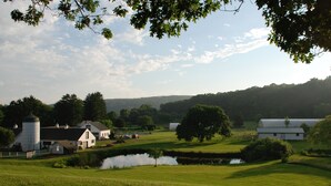 A rural landscape with a pond, barns, and houses.