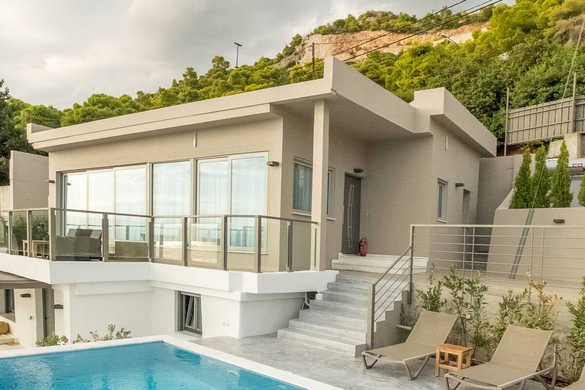 Une maison moderne dotée d’une piscine, d’un balcon et d’un escalier menant à une terrasse.