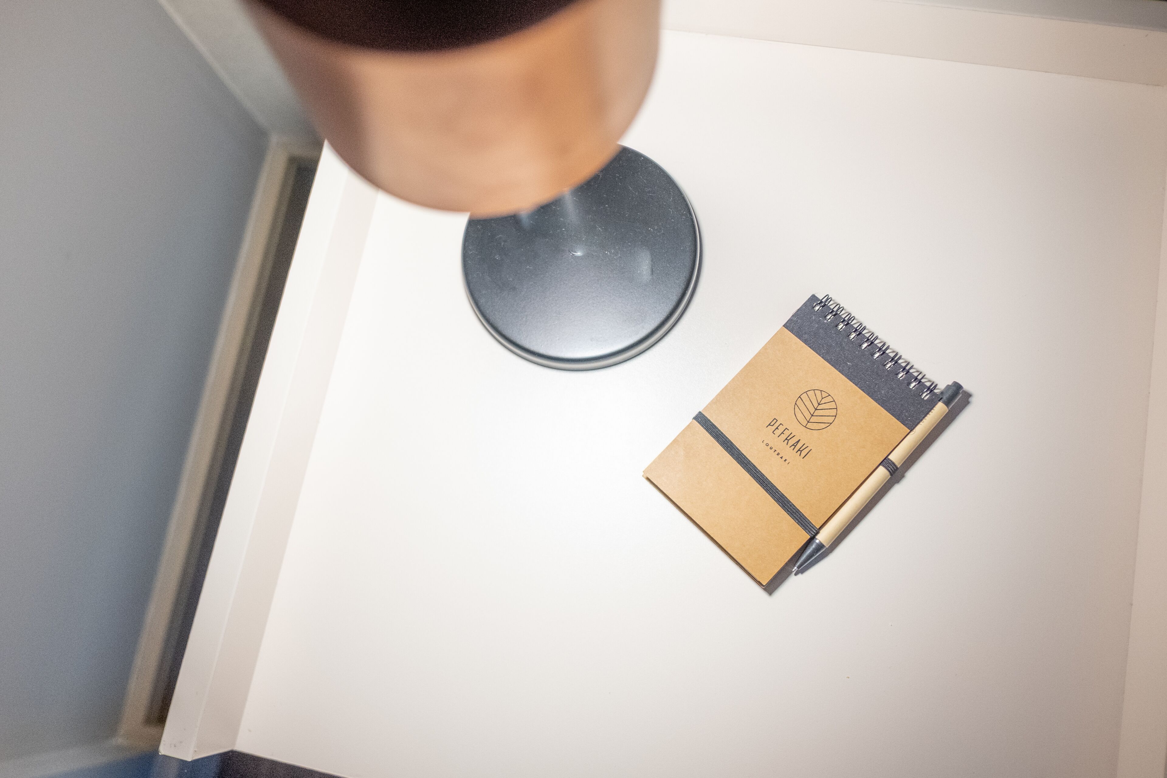 A notebook with a pen on a white surface.
