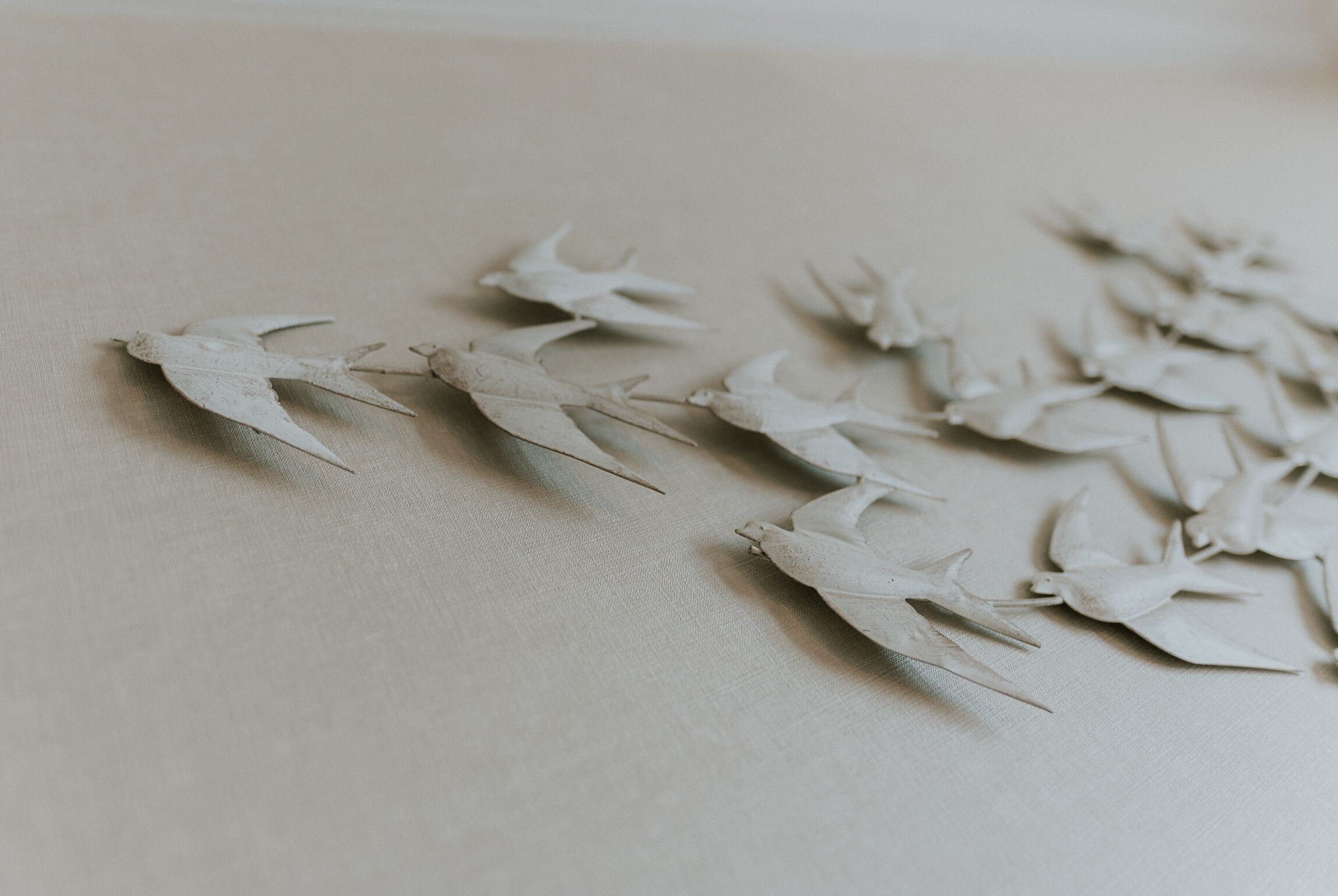 A collection of white origami birds on a textured surface.