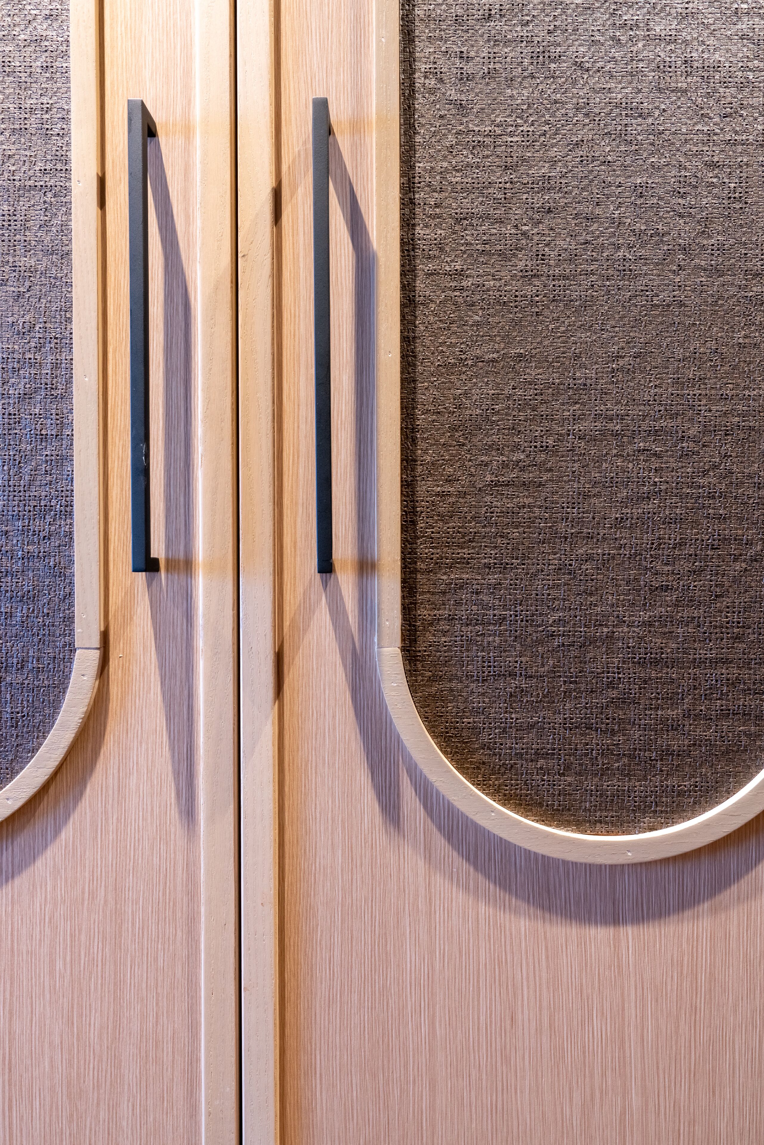 A wooden door with a textured panel and a circular window.