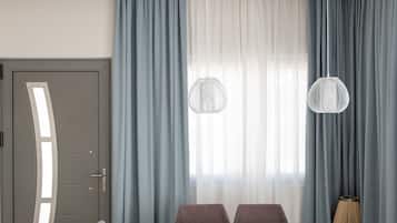 Un comedor moderno con una mesa de madera, seis sillas tapizadas de gris y dos lámparas colgantes.