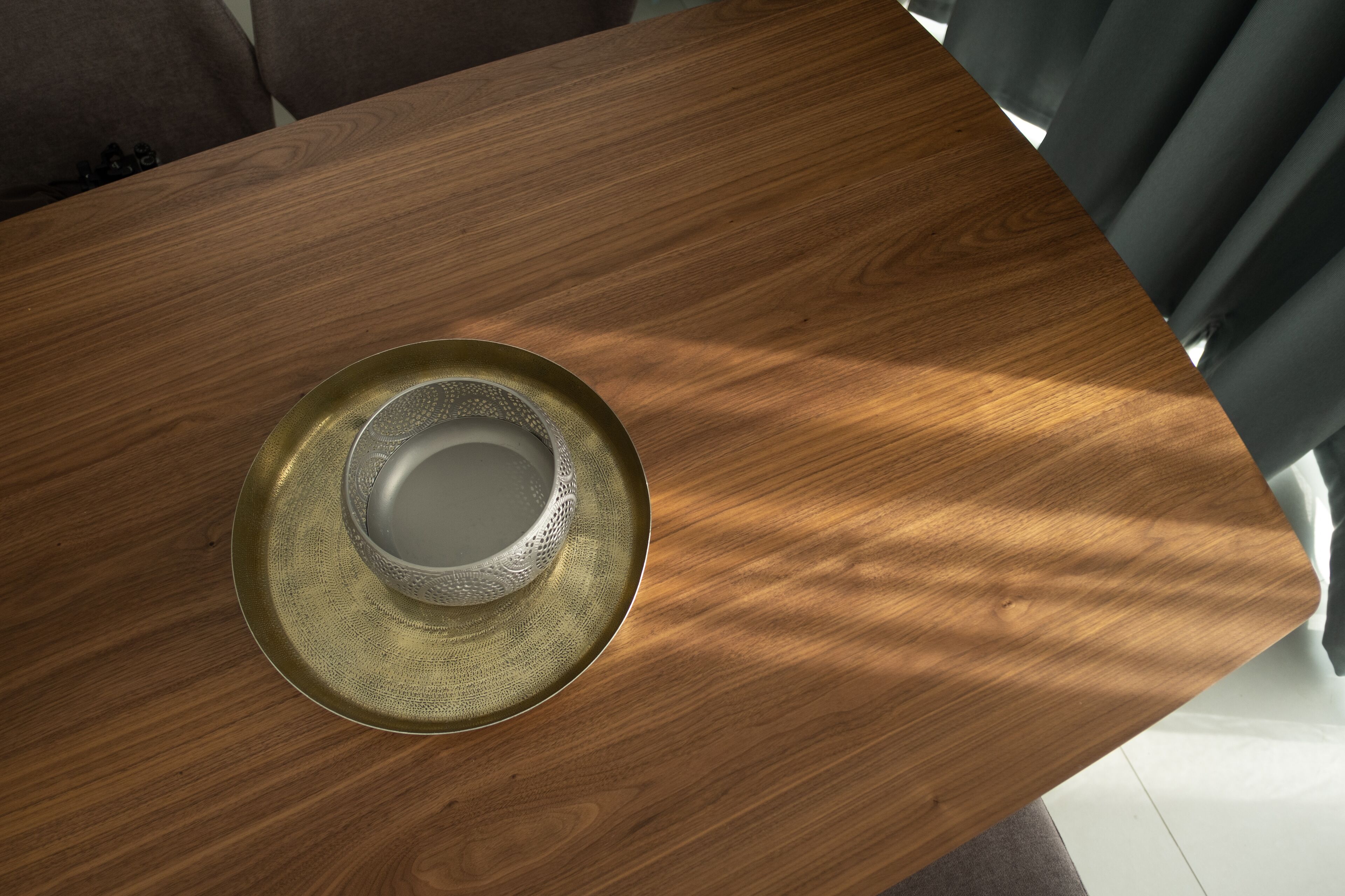 Una mesa de madera con un cuenco decorativo y un plato encima.