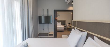 Una habitación de hotel con cama, televisor, escritorio y silla.