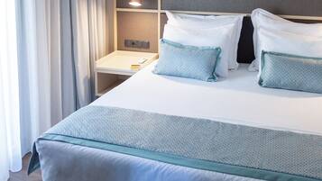 Un letto rifatto con una testiera, un comodino con una lampada e una decorazione a parete.