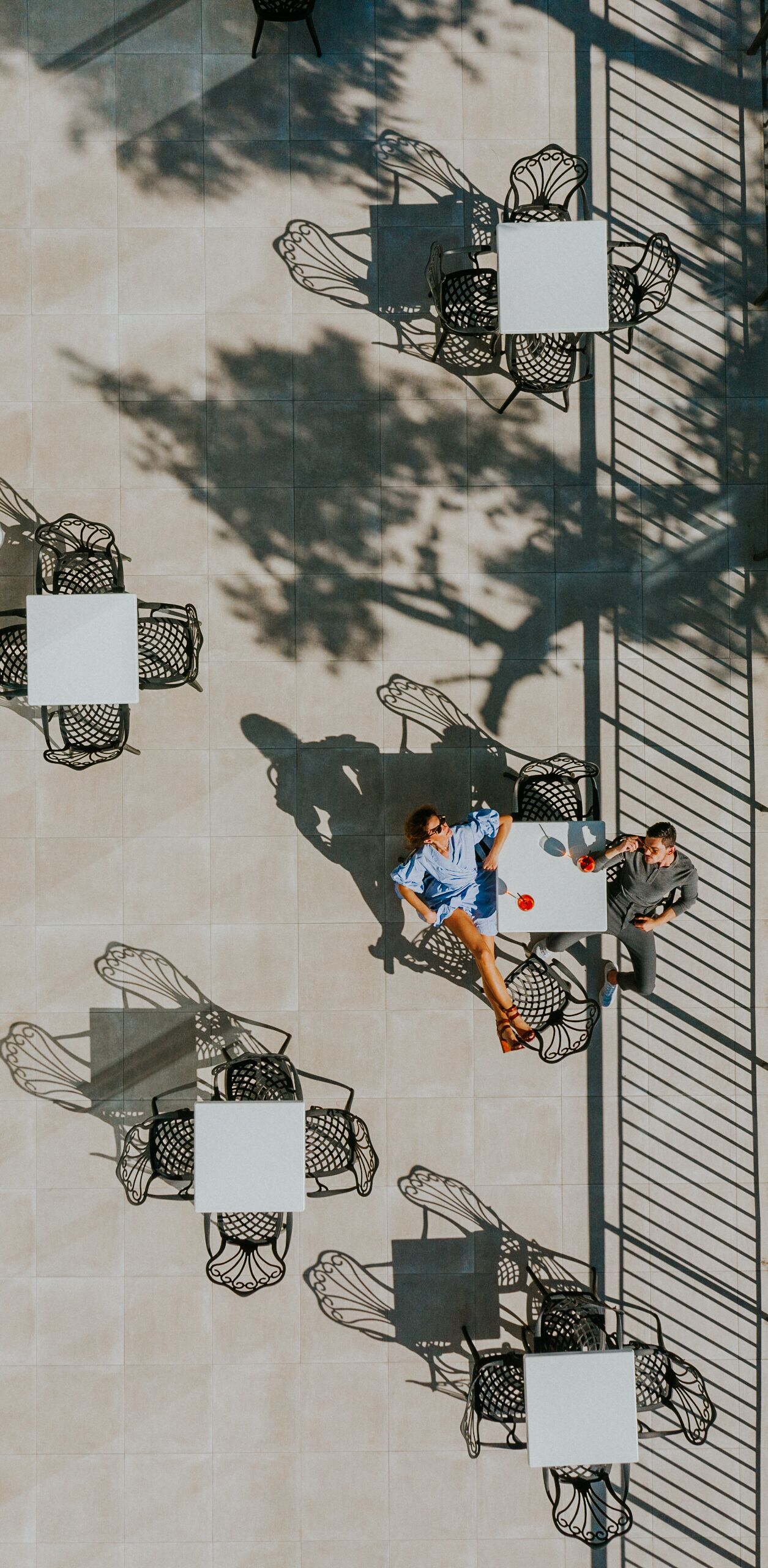 An outdoor café with tables and chairs arranged in a grid pattern.