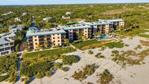 Resort com vários edifícios, praia e área de piscina.