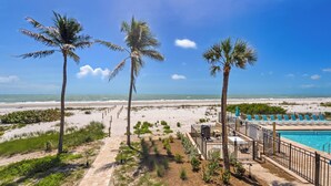 A beachside hotel with a pool, palm trees, and a clear view of the ocean. - OCEAN'S REACH 2D2: 2-Bdrm, Corner/Gulf-Front View, All Amenities Open! (Sanibel Island)