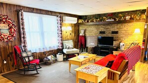 Un salon chaleureux avec une cheminée, des meubles en bois et un téléviseur.