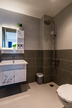 A modern bathroom with a shower, sink, and toilet. - HAPPYHOMES 102 Luxury Bui Vien Apartment (Ho Chi Minh City)