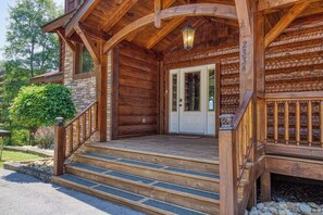 Step into this charming cabin, featuring a cozy porch with a lantern-style light and a beautifully maintained garden.
