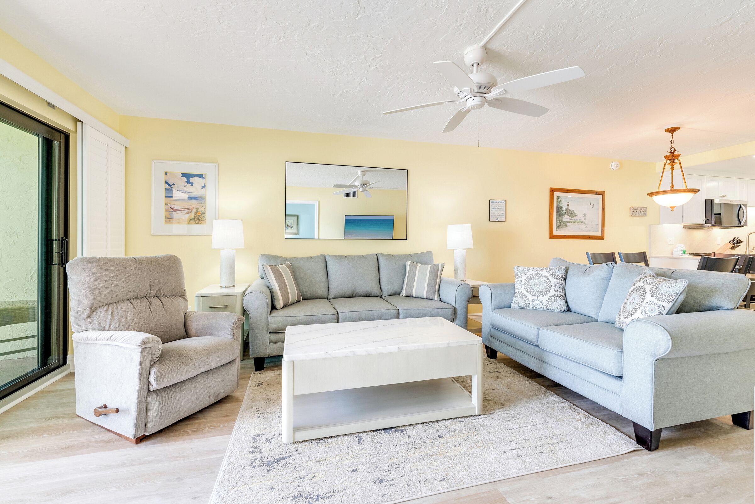 A living room with a sofa set, a coffee table, and a ceiling fan.