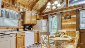 A kitchen with wooden cabinets, a white refrigerator, a stove, and a dining table with chairs.