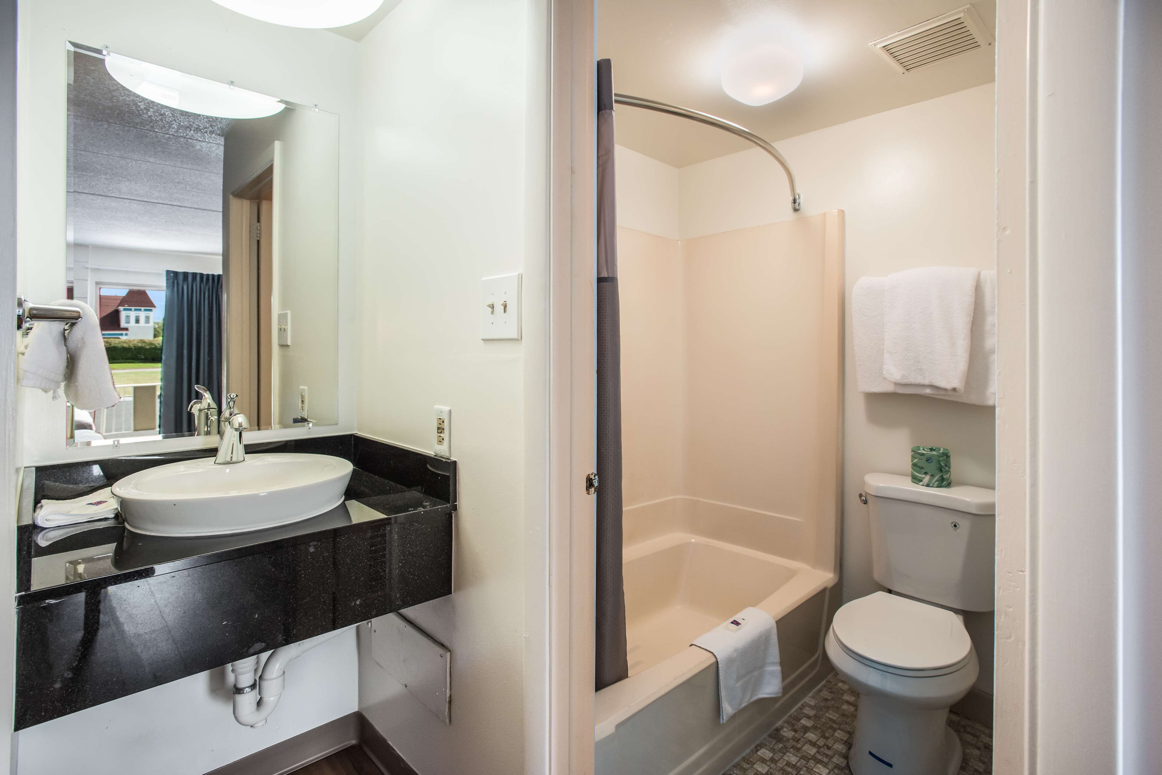 A bathroom with a sink, mirror, and toilet.