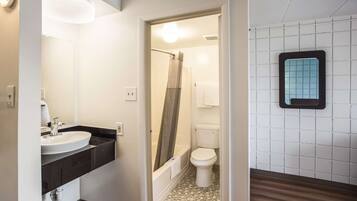 A bathroom with a sink, toilet, and shower.