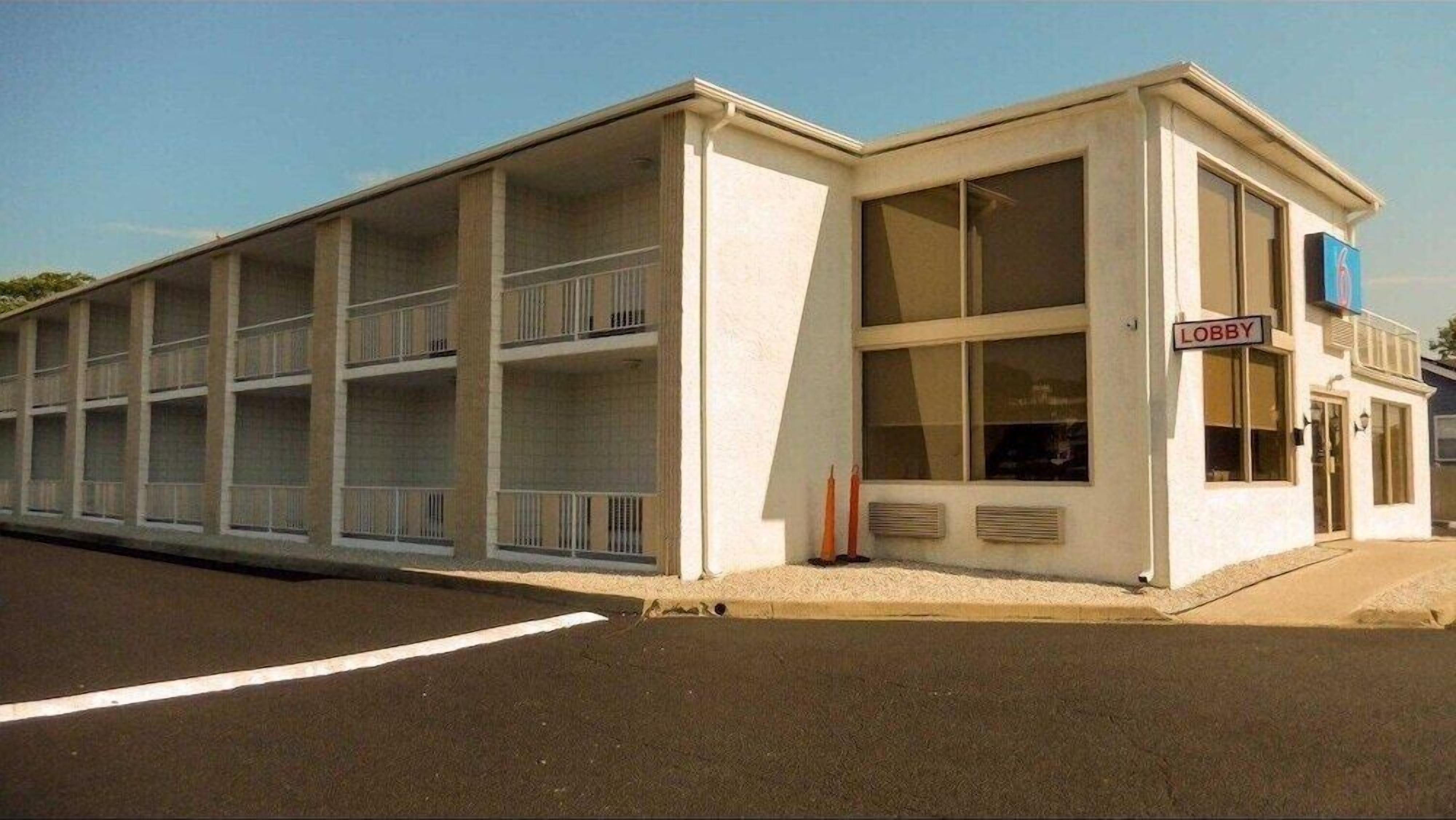 Un motel composé d’un bâtiment à deux étages, d’un hall d’entrée et d’un parking.
