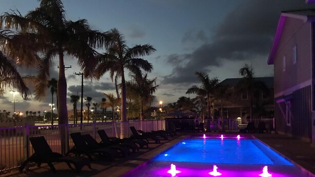 A swimming pool with water features at dusk. - Best of Padre Island! Less than 1.5 miles to Luby Beach! (Corpus Christi)