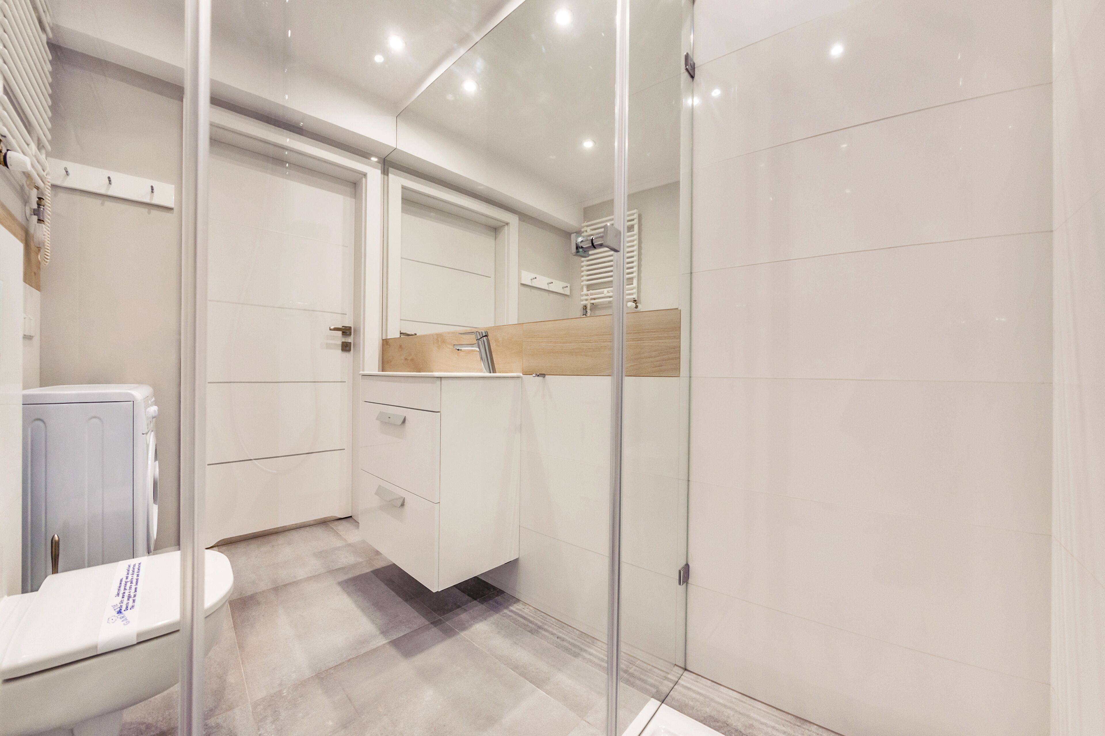 Un baño moderno con cabina de ducha de vidrio, inodoro y tocador con espejo.