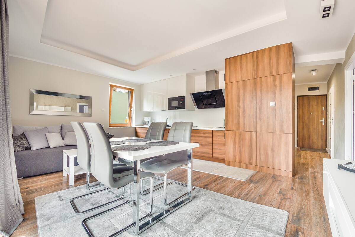 A modern apartment with a dining area, kitchen, and living space.