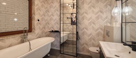 A modern bathroom with a freestanding bathtub, a glass-enclosed shower, and a sink with a mirror.