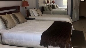 A hotel room with two beds, a mirror, a ceiling fan, and a door. - FAMILY FUN spacious 4 bedroom home with pool/spa, bbq, game room & 8 beds (Palm Desert)