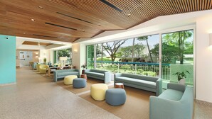 A spacious lobby with modern furniture, large windows, and a wooden ceiling. - Ocean & Sunset Views, FREE Parking & Washlet! (Honolulu)