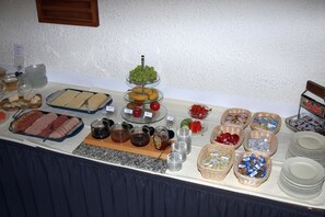 A buffet table with various food items including meats, cheeses, fruits, and condiments. - Hotel Weinstube Klasen (Cochem)