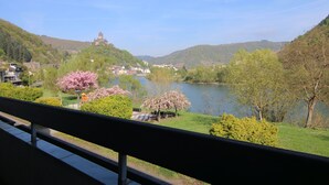 Una vista panorámica de un lago rodeado de colinas, con una estructura similar a un castillo al fondo.