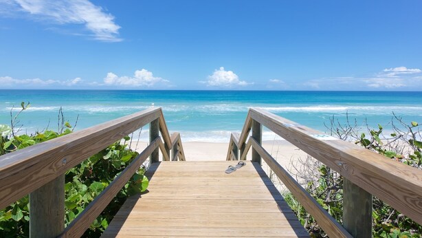 A wooden boardwalk leading to a beach with clear blue water and a bright sky. - Oceanfront 3-Bedroom / 2-Bath Luxury Townhouse in the heart of Melbourne Beach (Melbourne Beach)