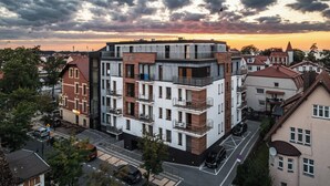 A modern multi-story building with a flat roof, balconies, and a sign reading "AQUARIUS." - Apartamenty Sun & Snow Ustka Aquarius (Ustka)