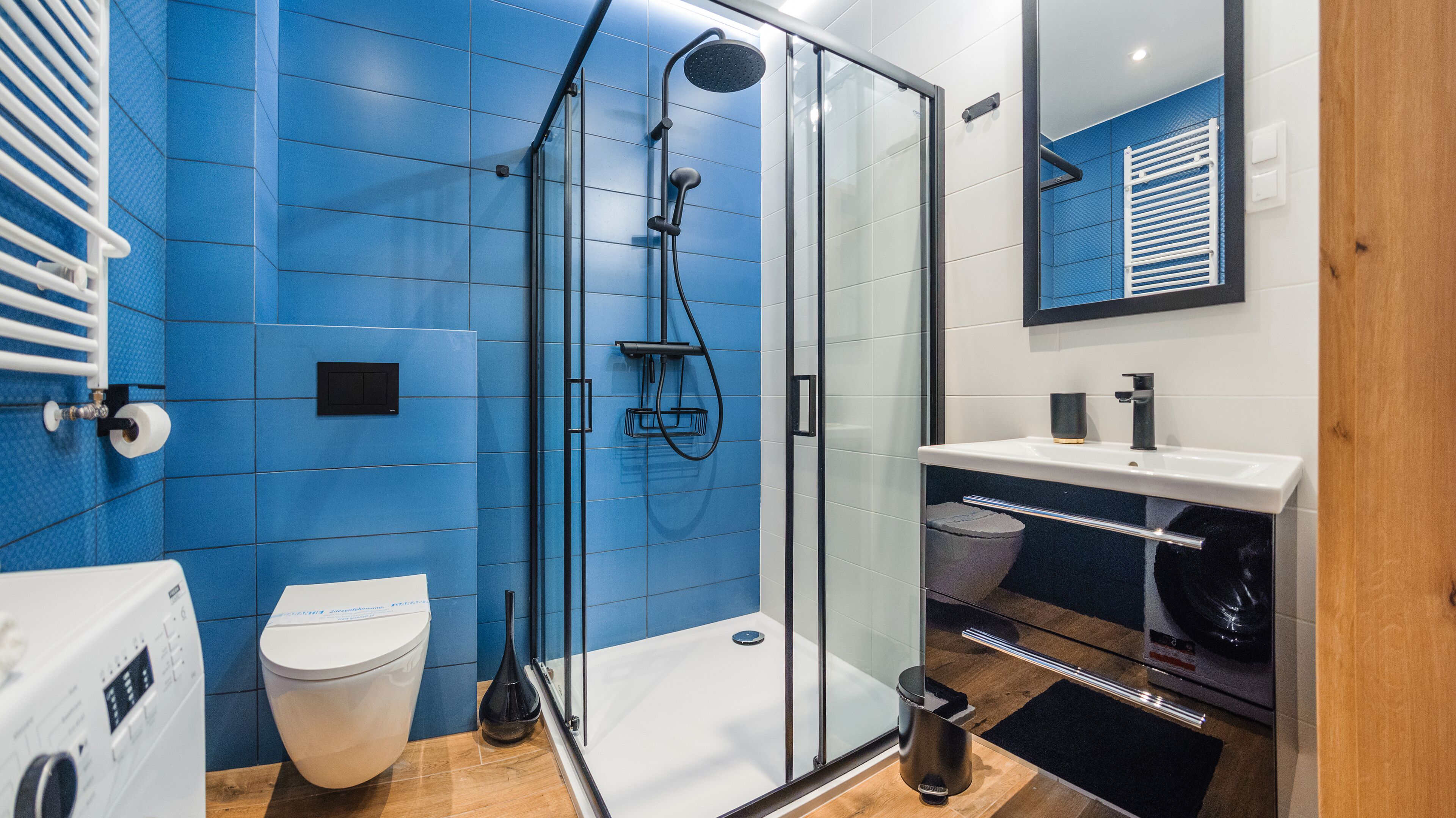 Une salle de bain moderne avec une douche à parois de verre, des toilettes et un lavabo avec un miroir au-dessus.