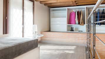 Ein modernes Zimmer mit Holzboden, einer Ziegelwand, einem weißen Kleiderschrank und einem Metallgestell.