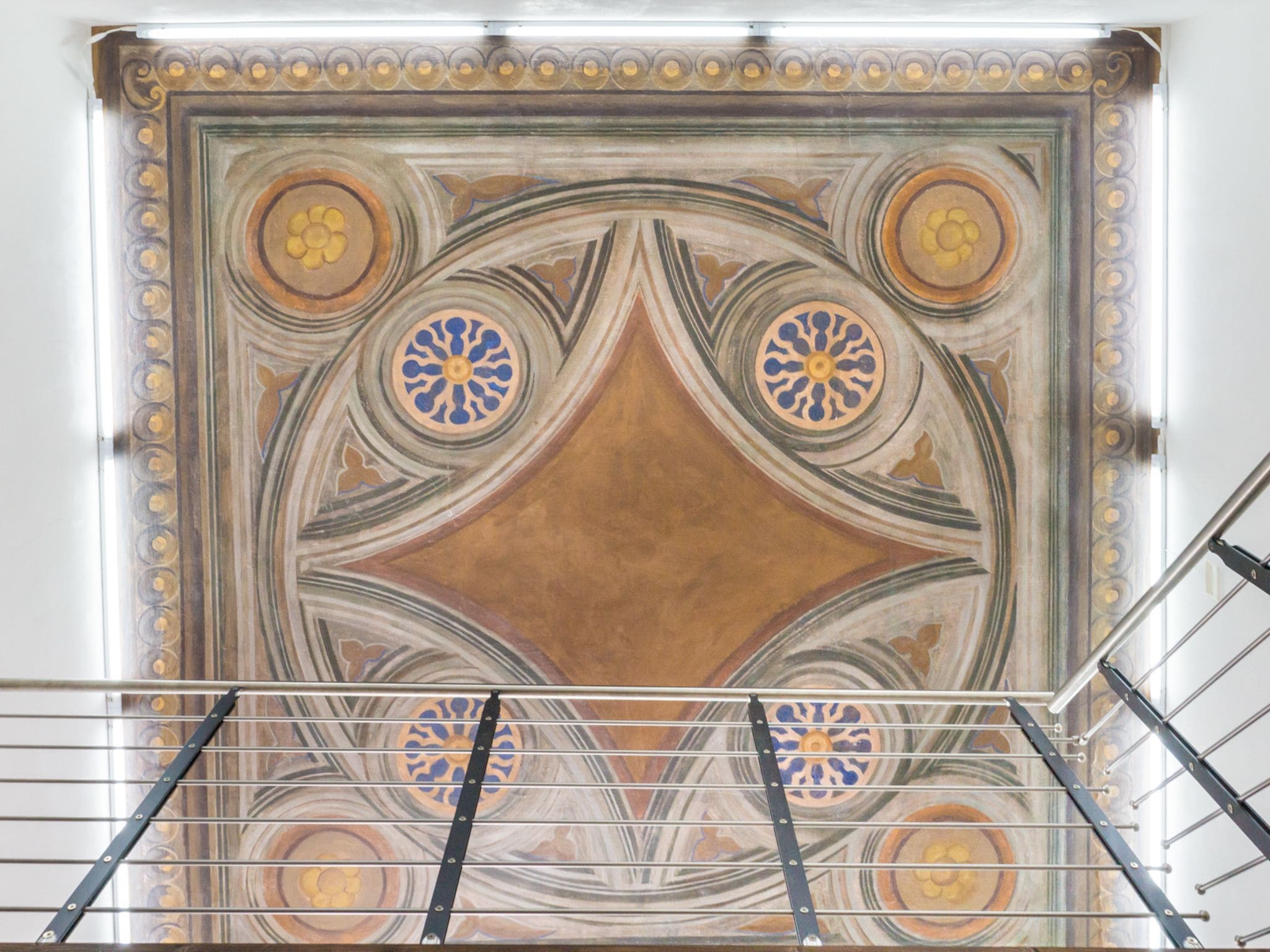 A ceiling with intricate floral patterns and a central diamond shape.