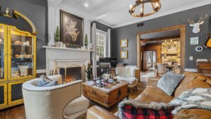 A cozy living room with a fireplace, leather sofa, and a yellow cabinet.