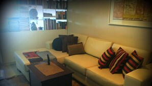 Un salon avec un canapé, une table basse et une bibliothèque remplie de livres.