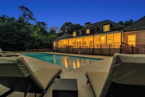 A swimming pool with lounge chairs, a brick building with large windows, and a well-maintained lawn. - Pool estate with soccer field, sleeps 16 (Lithonia)