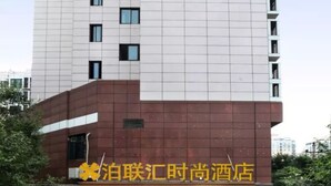 Un hôtel au design moderne, dont l’enseigne, bien visible, est ornée de caractères chinois.