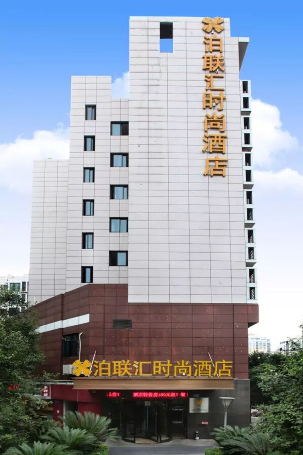A hotel with a modern design, featuring a prominent sign with Chinese characters.