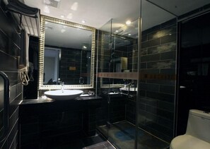A modern bathroom with a large mirror, two sinks, and a glass shower enclosure.